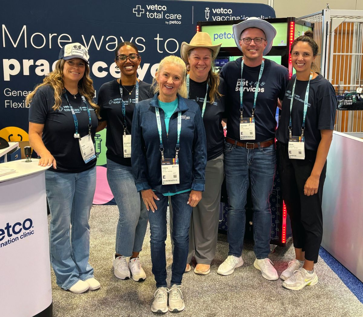 Vetco Total Care and talent acquisition partners smiling together at a veterinary conference booth.