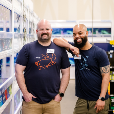 two male employees look and smiling at the camera
