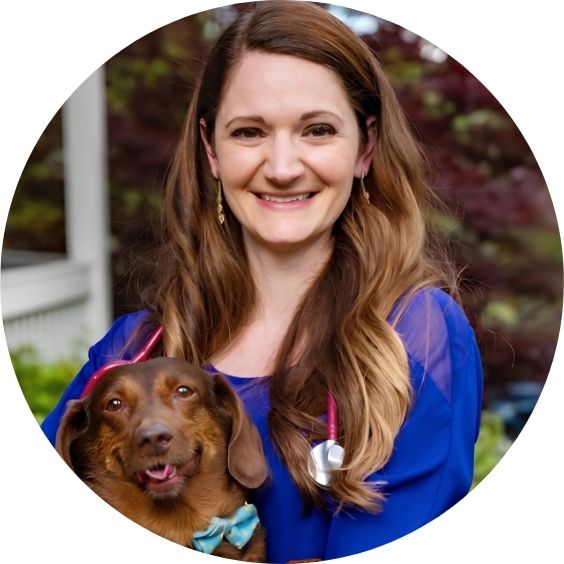 Dr. Ward smiling while holding a dog and wearing a stethoscope.
