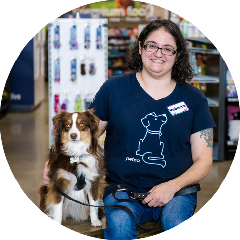 A women sitting with a mini-Australian shepherd dog