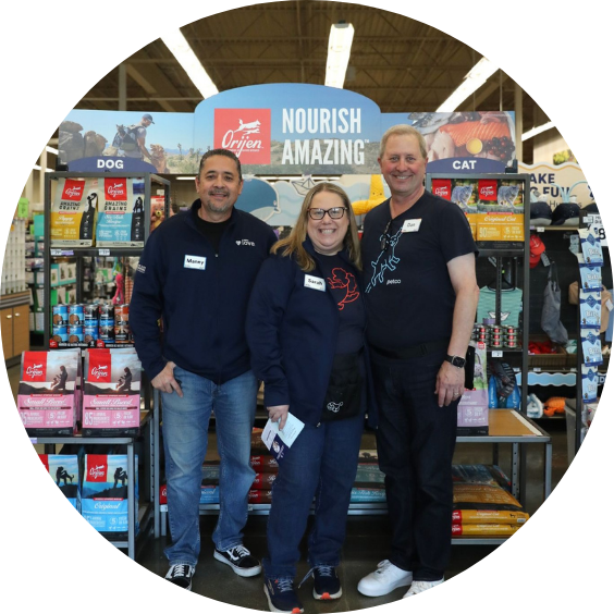 Three store employees standing in front of a display shelf