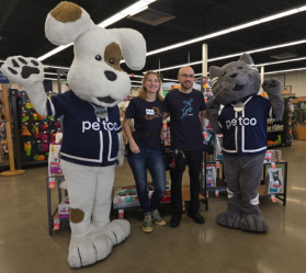 Petco mascots and staff in store aisle.