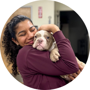 Woman smiling and squishing a dog's face