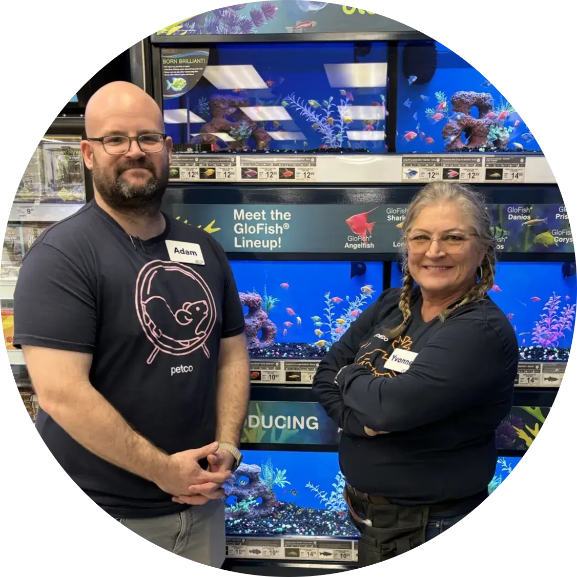 Two employees stand in front of a wall of Aquariums