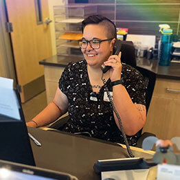 Vet receptionist sitting at the receptionist desk while on the phone