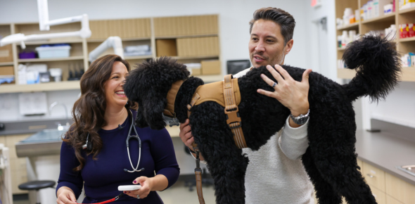 Veterinarian and pet owner with happy dog.