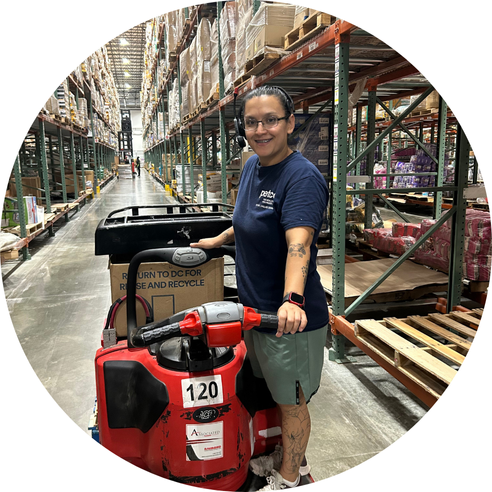 Worker using pallet jack in warehouse