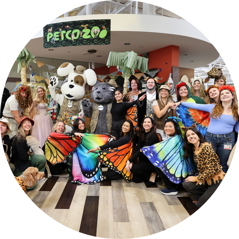 Group in costumes under Petco Zoo sign