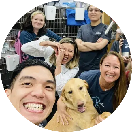 Group of veterinarians smiling with a dog