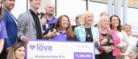 Group of people holding a large ceremonial check for $1,500,000 from Petco Love to Brandywine Valley SPCA, dated May 2022, with several individuals holding small dog