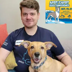 Jeremy Pierce with arm around dog while both are posing for a picture