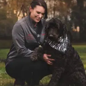 Mary Lee crouching down while petting a dog