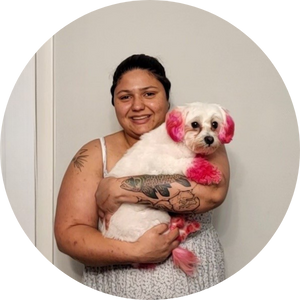 Yaz Thompson holding white dog with pink ears and paws.