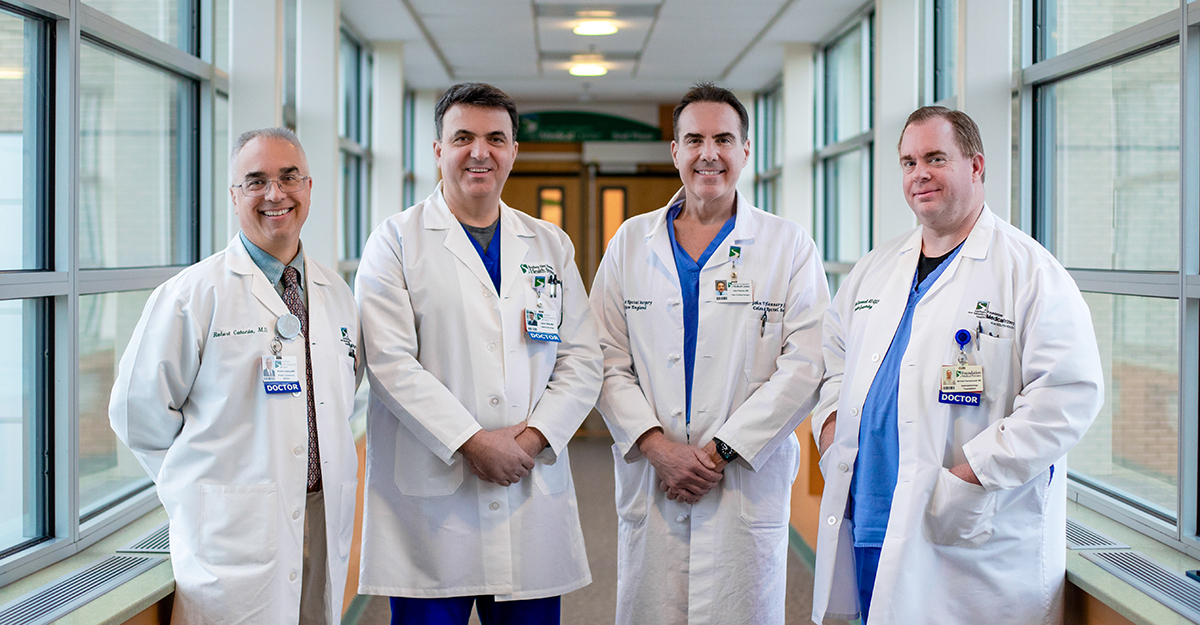 Group smiling for the camera wearing lab coats