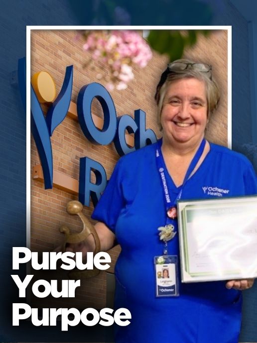 A woman wearing blue medical scrubs holds a framed certificate and award in front of a hospital sign. Text reads, "Pursue Your Purpose.”
