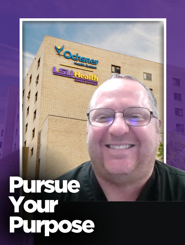 Man in black shirt in front of a hospital