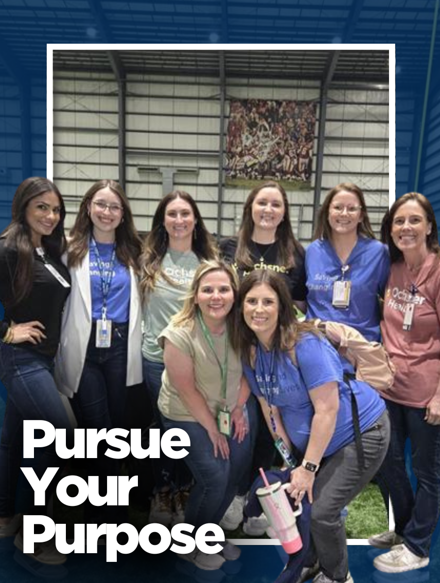 A group of eight smiling women, dressed in casual and professional attire with Ochsner Health branding, pose together in an indoor facility with a high ceiling and green turf. The text "Pursue Your Purpose" overlays the bottom left corner.