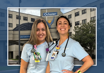 Two smiling nurses from the Med Tele unit at Ochsner Baton Rouge stand together in their scrubs. The background features a modern hospital building.