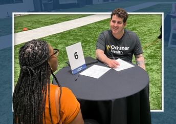Male recruiter sitting at a table interviewing a candidate at a recruitment event