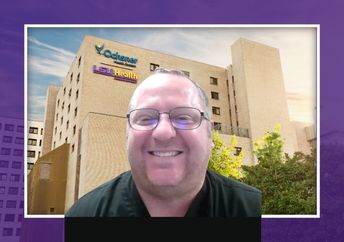 Man in black shirt in front of a hospital