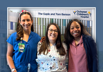 Three smiling female healthcare professionals in colorful scrubs stand in front a rendering of Ochsner Children's Hospital.