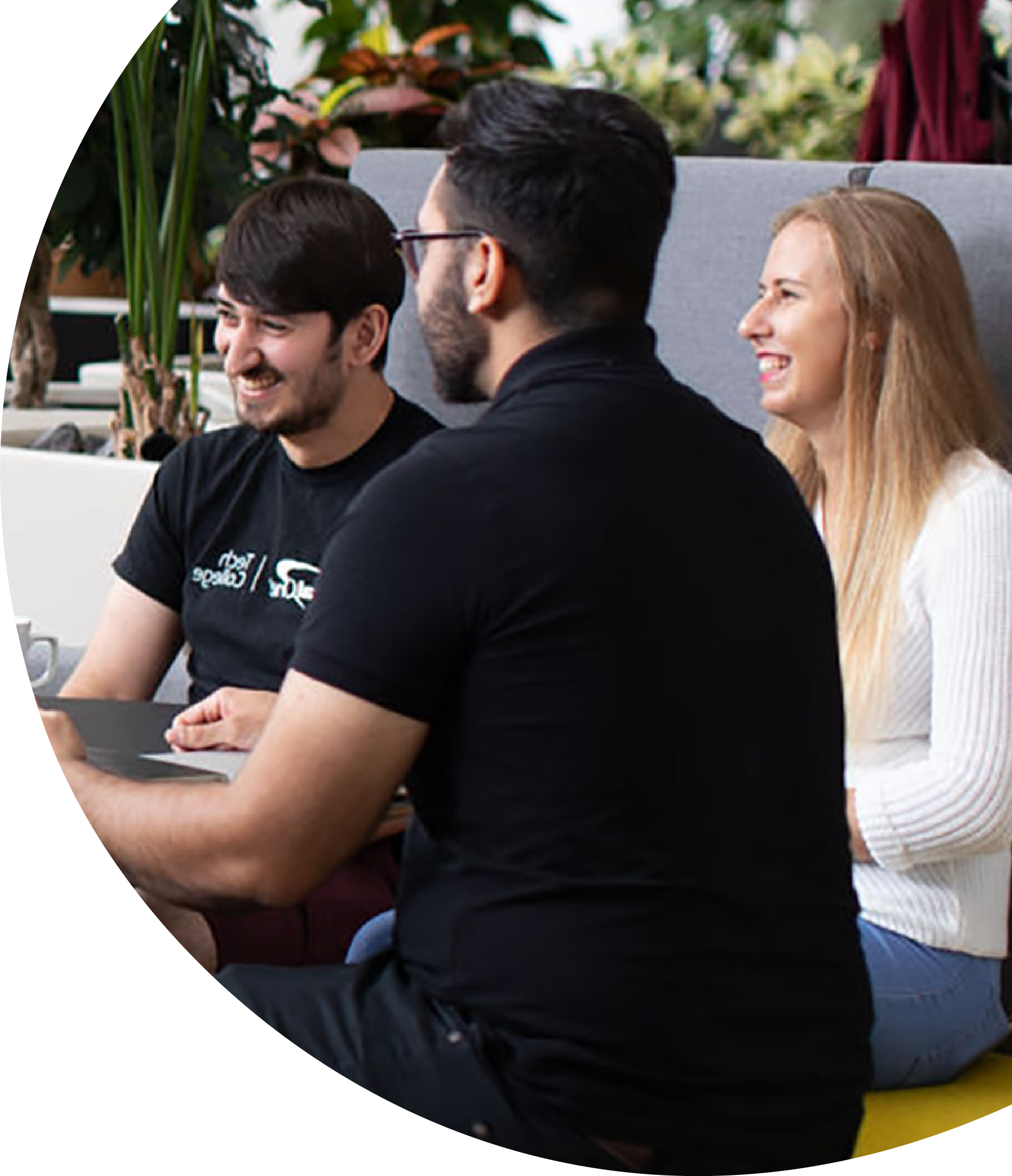 Team chatting and smiling in a bright office space.