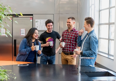 Colleagues laughing and chatting in a break area.