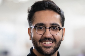 Smiling person wearing glasses, close-up portrait.