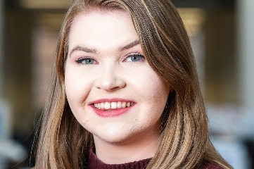 Smiling woman in an office setting.