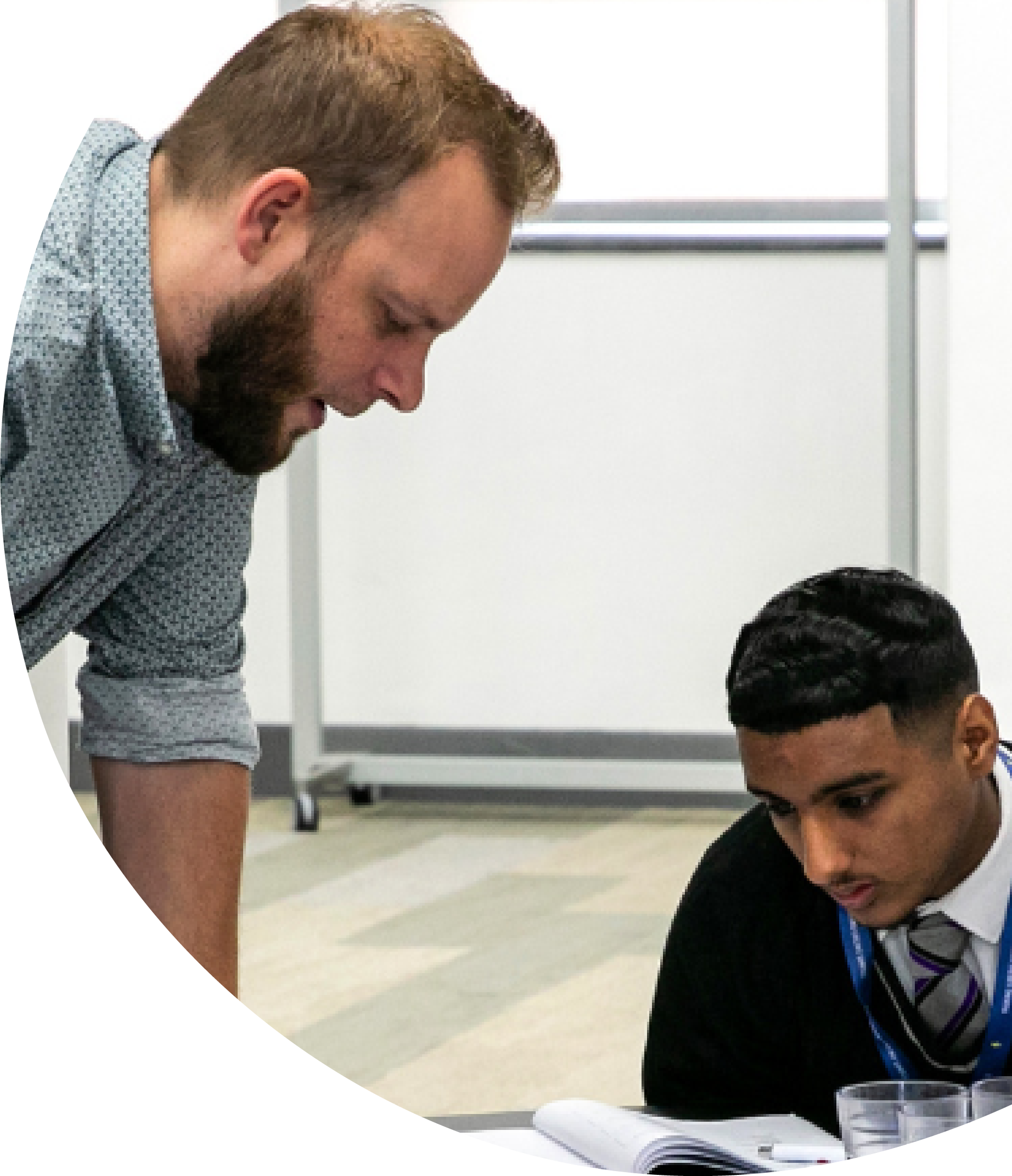 A teacher guides young men in a group discussion.