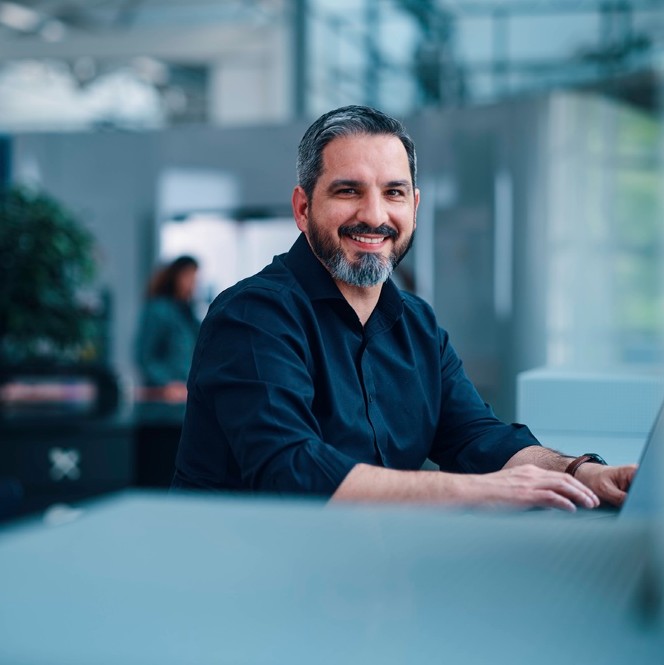 Professional man smiling while working on laptop