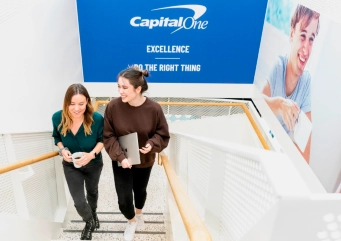 Two women walking up stairs, smiling and talking.