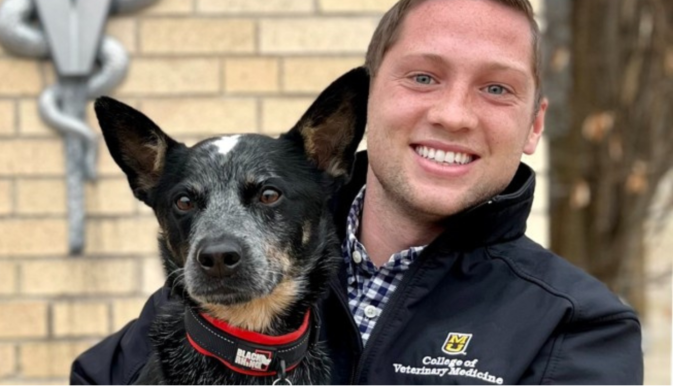 Man stands with Blue Heeler dog