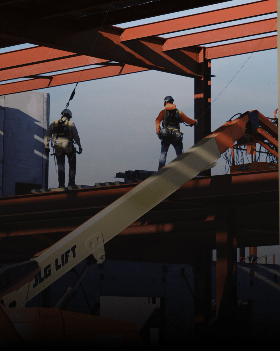Construction worker carrying beam.