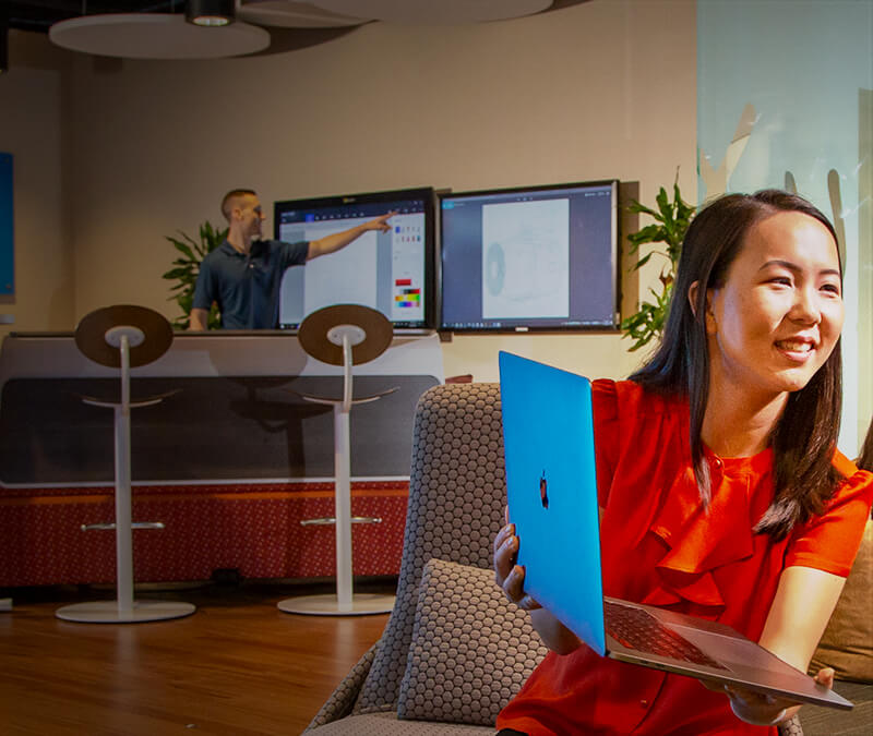 Woman showing laptop screen to another person