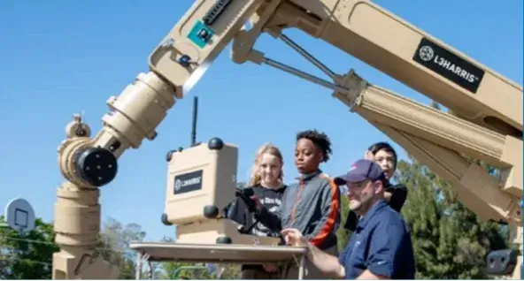 Employee showing children how a piece of equipment operates