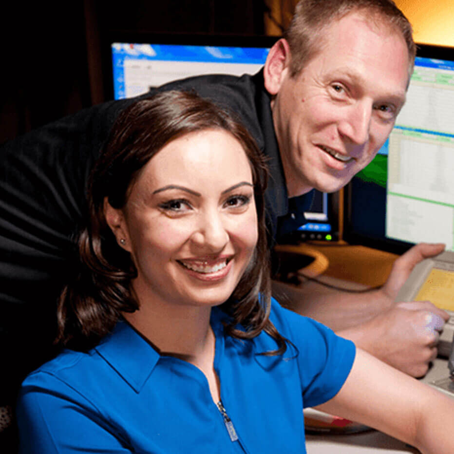 Male and female employees at desk smiling