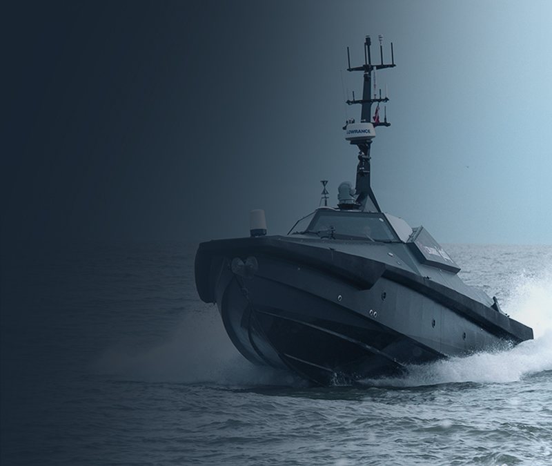 Naval ship sailing in dark waters under cloudy skies.