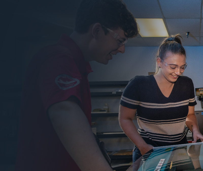 Two young individuals discussing or studying indoors.
