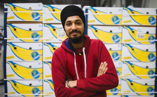 person in front of boxes of products smiling