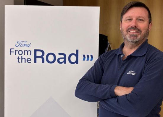 Leonardo, a Ford Supplier Techinical Assistant, posing in front a Ford From the Road sign