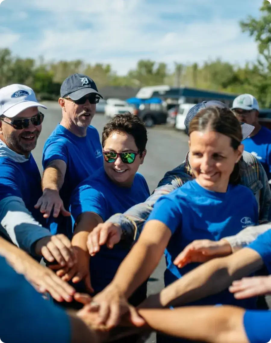Group of volunteers in a circle with their hands together