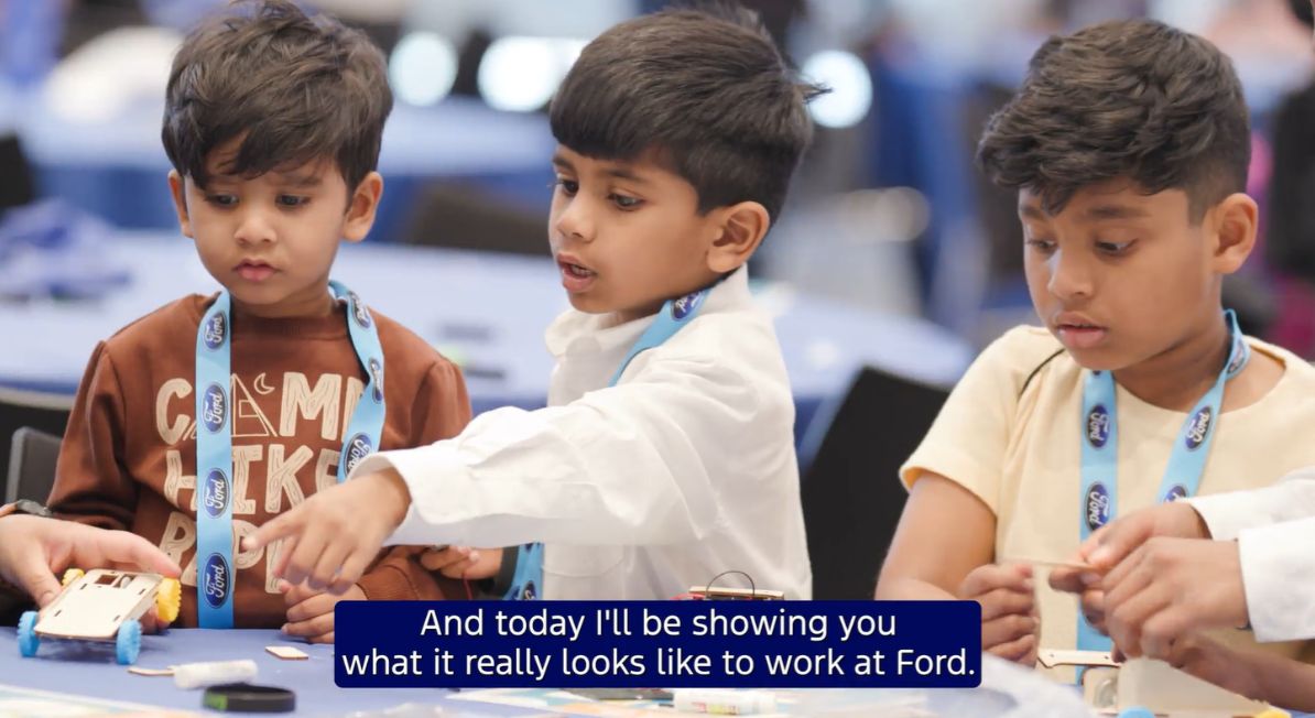 Three children of Ford employees complete an activity at Bring Your Child to Work Day.