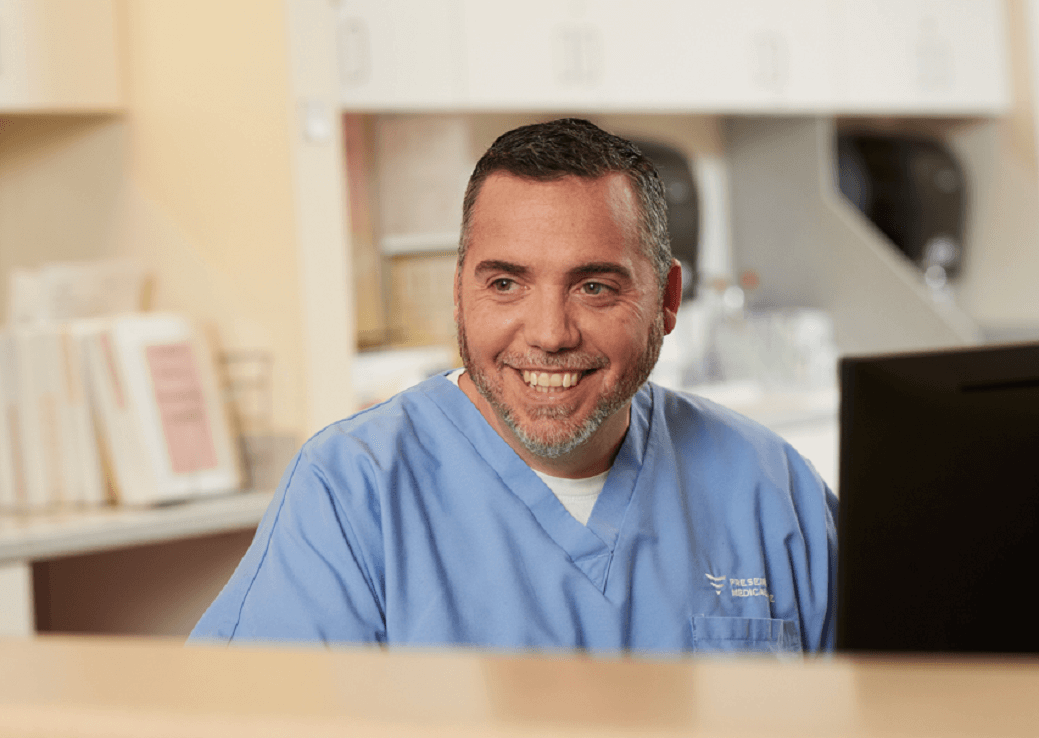 Nurse in blue scrubs smiling