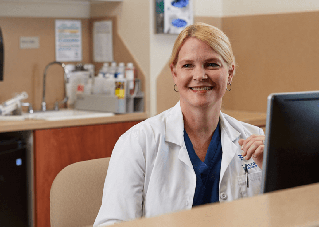 Women wearing a white lab coat and smiling for the picture