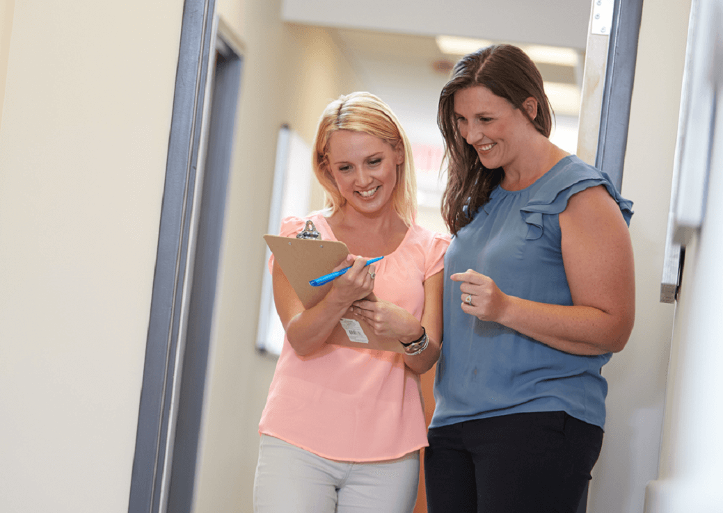 Two people looking at a clipboard