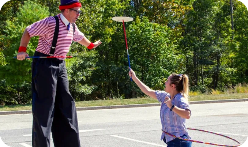 tall circus mand and lady spinning plate on stick