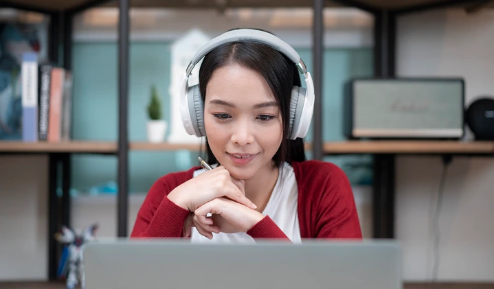 a woman with headphones looking at a computer
