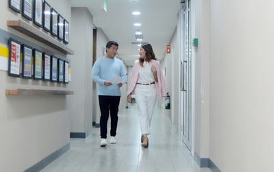 a woman and man walking down a hallway