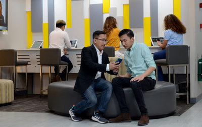 two men sitting looking at a phone